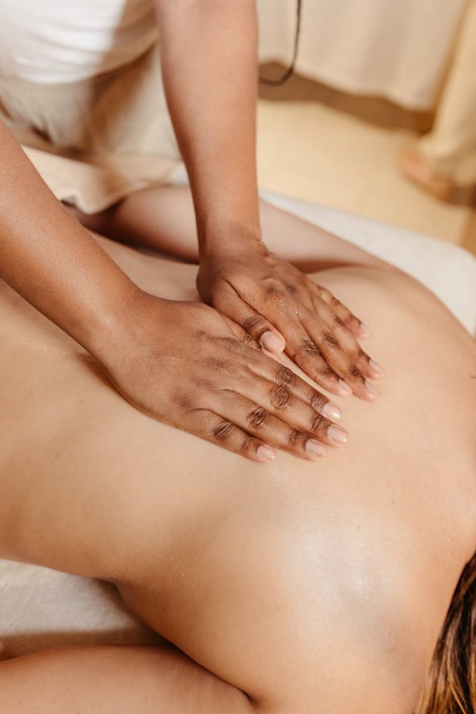 Close-up of a relaxing spa massage with a therapist massaging a woman's back.